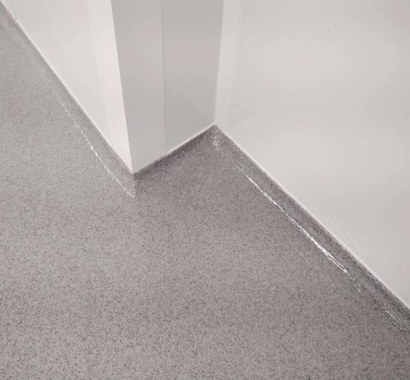 Seamless speckled epoxy floor with integrated coving at the wall junction