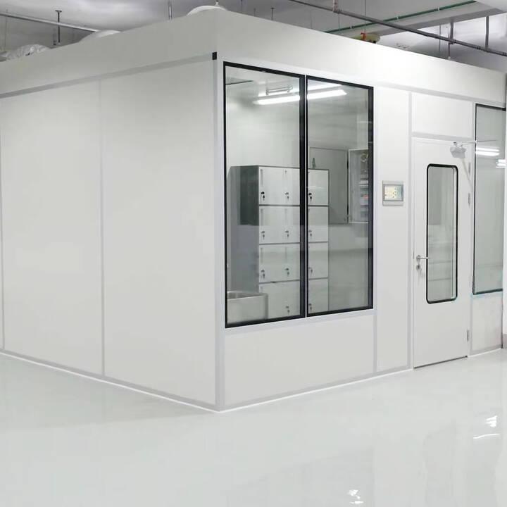 White modular cleanroom partition with a flush double-glazed window and a cleanroom door